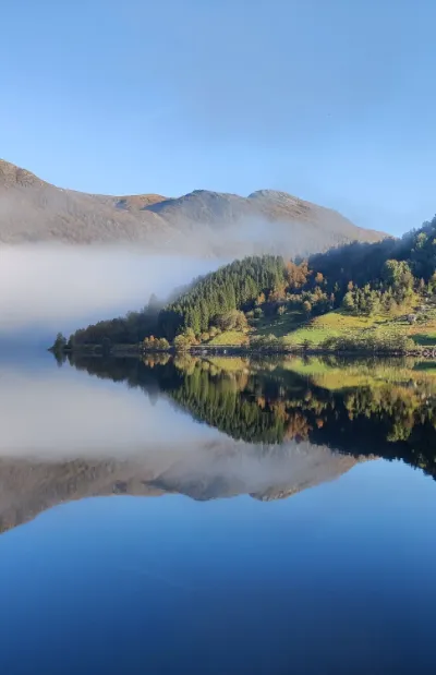 Billede av Viksdalsvatnet og solfylte fjellsider.